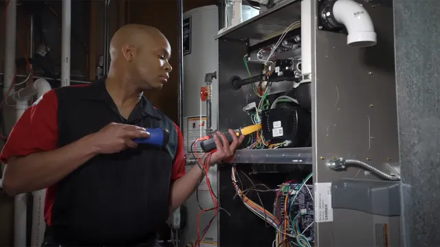 Professional HVAC expert fixing furnace unit in Little Falls, NJ