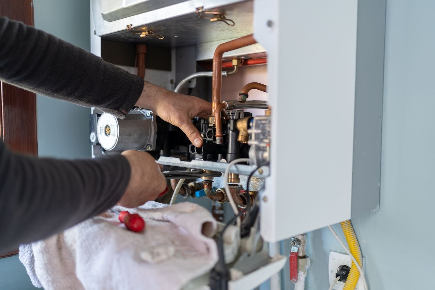MG Plumbing Heating and Air Conditioning team fixing a home heating unit