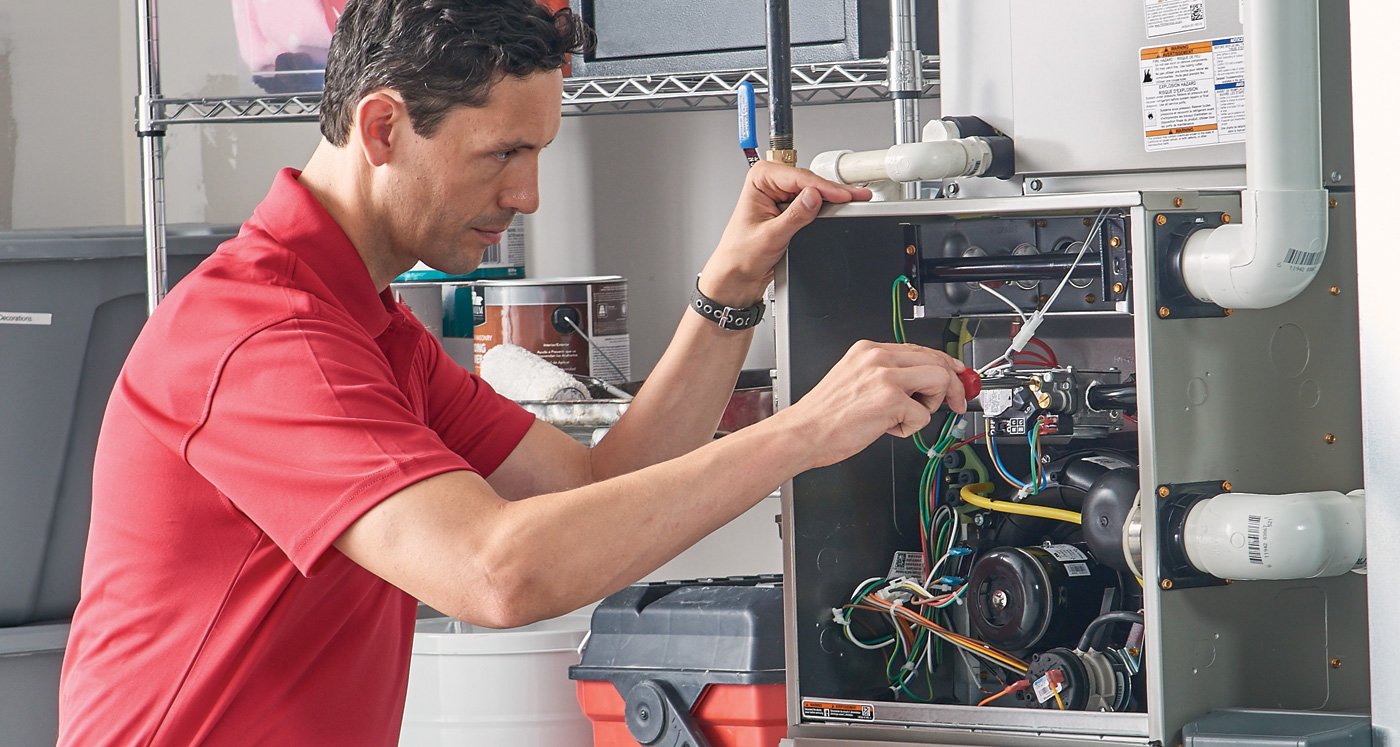 Heating specialist fixing a residential furnace unit